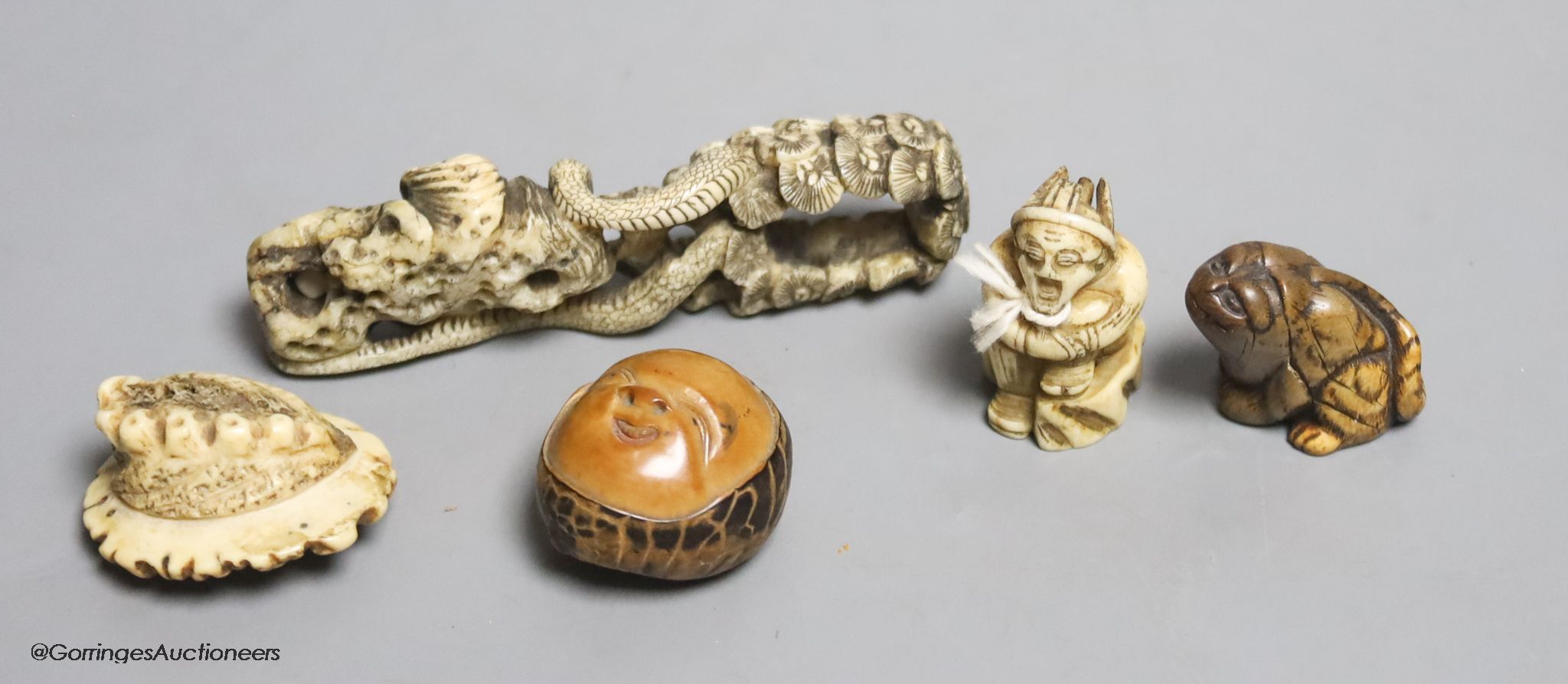 Two Japanese stag antler netsuke, a stained ivory tiger netsuke, a walrus ivory carving and a nut mask netsuke